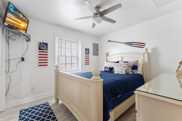 bedroom featuring ceiling fan, electric panel, baseboards, and light wood finished floors