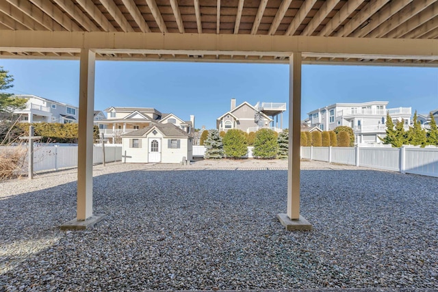 view of yard featuring an outbuilding, a fenced backyard, and a residential view