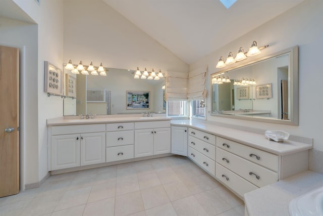 bathroom featuring tile patterned flooring, vaulted ceiling, double vanity, and a sink