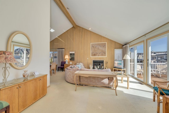 living room with a glass covered fireplace, beam ceiling, wood walls, and light carpet