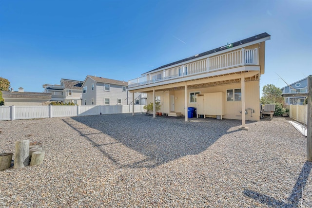 back of property featuring a wooden deck and a fenced backyard