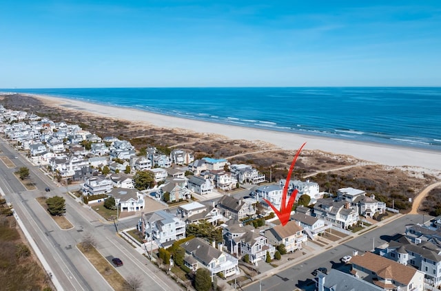 bird's eye view featuring a water view, a beach view, and a residential view