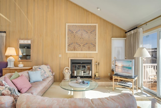 living room with a glass covered fireplace and vaulted ceiling