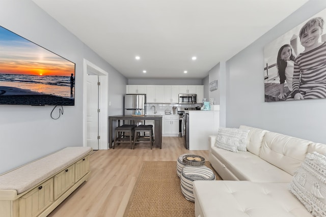 living room featuring sink and light wood-type flooring