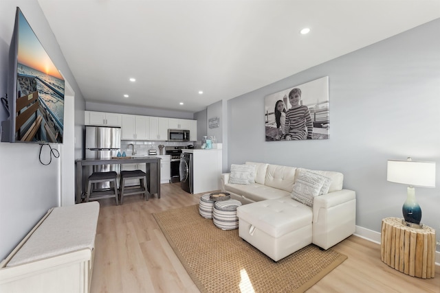 living room featuring sink and light hardwood / wood-style floors