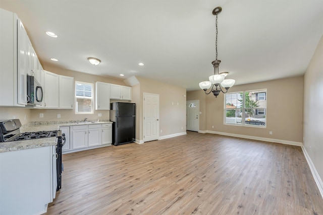 14 E New York Ave, Villas, NJ 08251 - kitchen with freestanding refrigerator, gas stove, a chandelier, light wood-style flooring, and hanging light fixtures