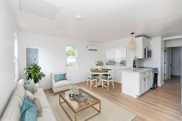 living room featuring electric panel, light hardwood / wood-style flooring, and a wall mounted air conditioner