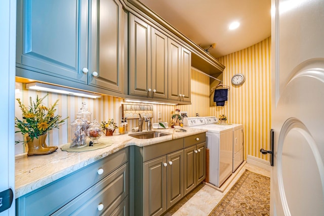 laundry area featuring cabinets, independent washer and dryer, and sink