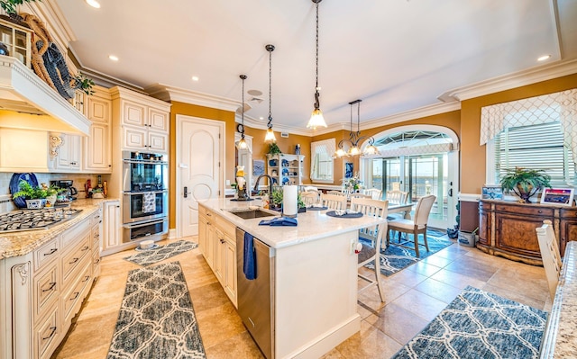 kitchen featuring sink, light stone counters, pendant lighting, a center island with sink, and appliances with stainless steel finishes