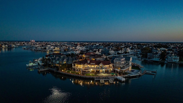 aerial view at dusk featuring a water view