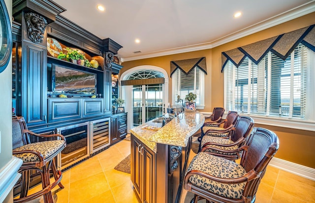 bar featuring light stone counters, light tile patterned floors, and ornamental molding