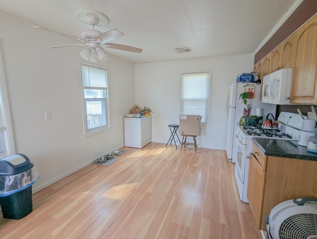 kitchen with a ceiling fan, white appliances, a healthy amount of sunlight, and light wood finished floors