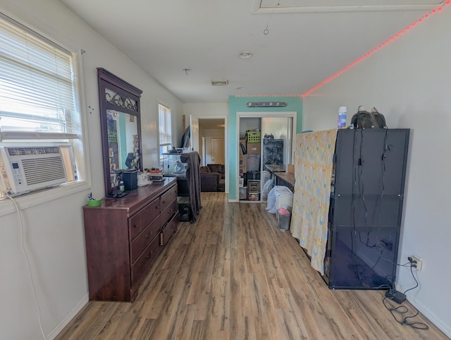 office featuring baseboards, attic access, wood finished floors, and a healthy amount of sunlight