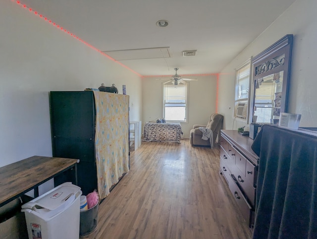 bedroom featuring visible vents, attic access, and wood finished floors