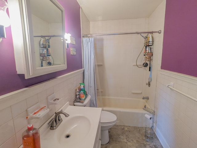 bathroom featuring vanity, shower / tub combo, wainscoting, tile walls, and toilet