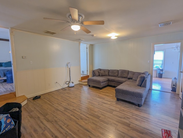 living area featuring wood finished floors, visible vents, and ceiling fan