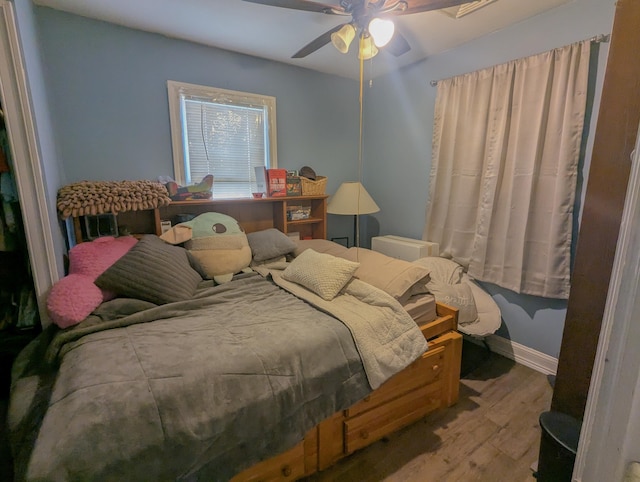 bedroom featuring a ceiling fan, wood finished floors, and baseboards