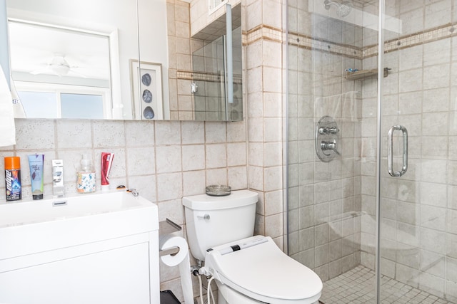 bathroom featuring vanity, toilet, tile walls, walk in shower, and tasteful backsplash