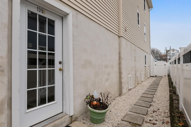 view of side of property with a fenced backyard and stucco siding