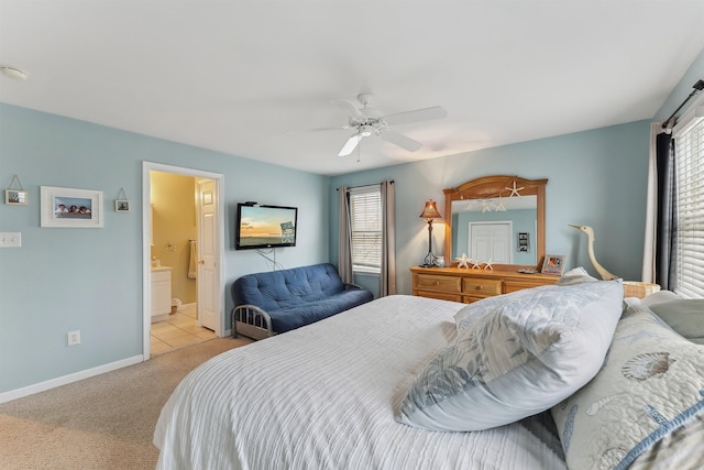 carpeted bedroom with ceiling fan, baseboards, and ensuite bathroom