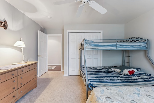 bedroom featuring baseboards, visible vents, a ceiling fan, light colored carpet, and a closet