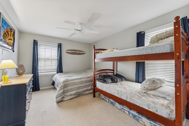 carpeted bedroom with ceiling fan and baseboards