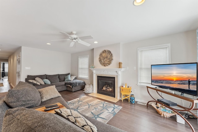 living area with a fireplace with flush hearth, wood finished floors, a wealth of natural light, and recessed lighting