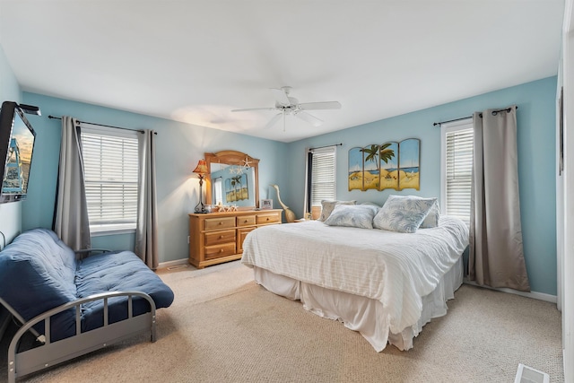 bedroom featuring light carpet, baseboards, visible vents, and a ceiling fan