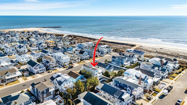 drone / aerial view with a view of the beach, a water view, and a residential view