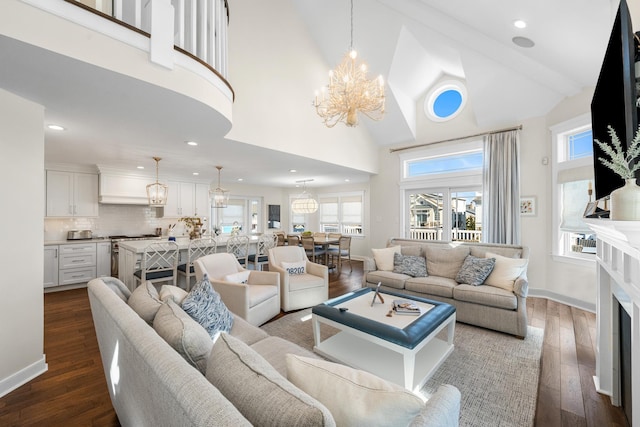 living room featuring healthy amount of natural light, a chandelier, dark wood-style flooring, high vaulted ceiling, and recessed lighting