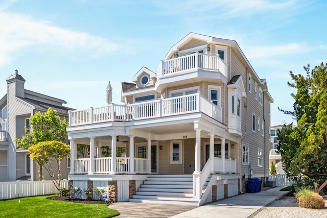 view of front of property featuring a balcony, covered porch, fence, and stairway