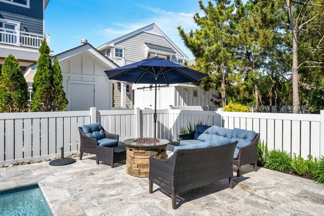 view of patio featuring a fenced backyard and an outdoor living space with a fire pit