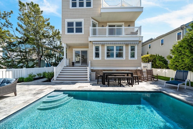 back of house featuring a balcony, a patio, and fence