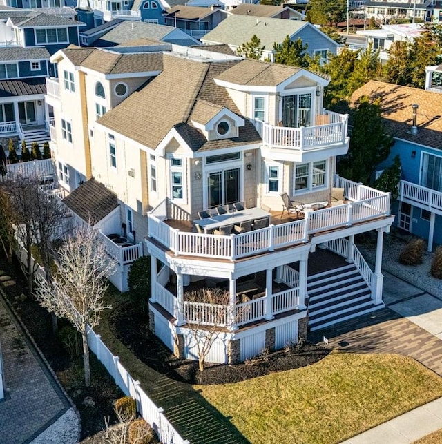 rear view of property with a residential view, roof with shingles, fence, and a balcony