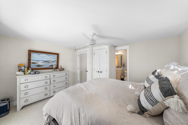 bedroom with light colored carpet, ceiling fan, and ensuite bath