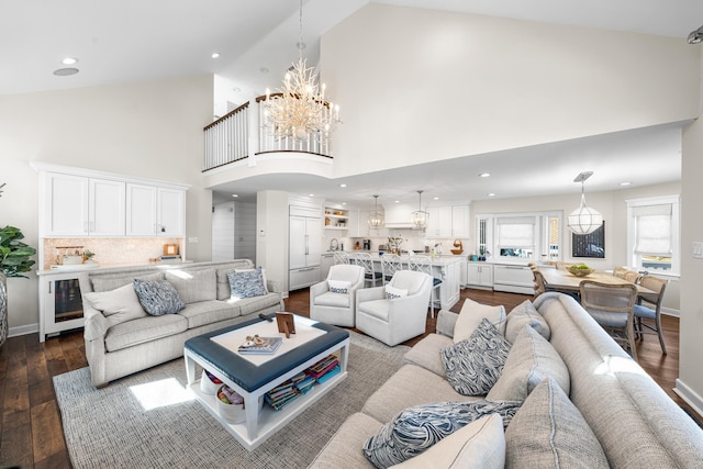 living area featuring dark wood-style floors, beverage cooler, baseboards, and an inviting chandelier