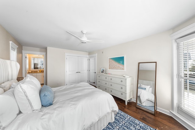 bedroom with dark wood finished floors, a closet, a ceiling fan, ensuite bath, and baseboards