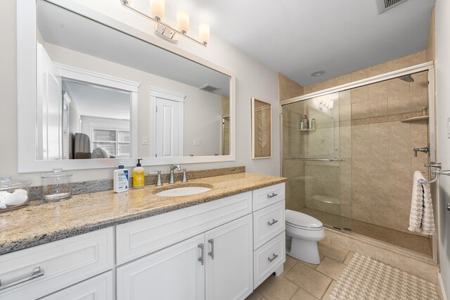 full bathroom with toilet, a stall shower, visible vents, and vanity