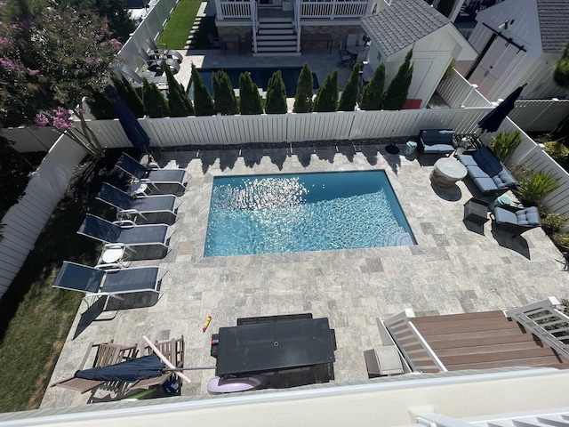 view of pool featuring stairway, a patio area, a fenced backyard, and a fenced in pool