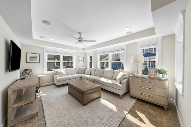 living room featuring ceiling fan, recessed lighting, a raised ceiling, and baseboards