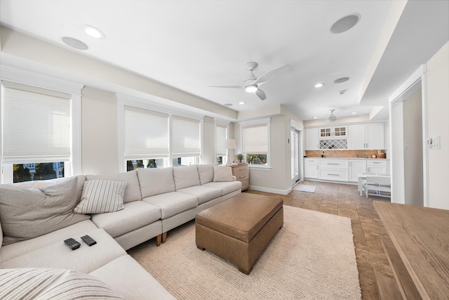 living area featuring baseboards, a ceiling fan, and recessed lighting