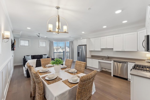 dining area with a healthy amount of sunlight, ornamental molding, and wood finished floors