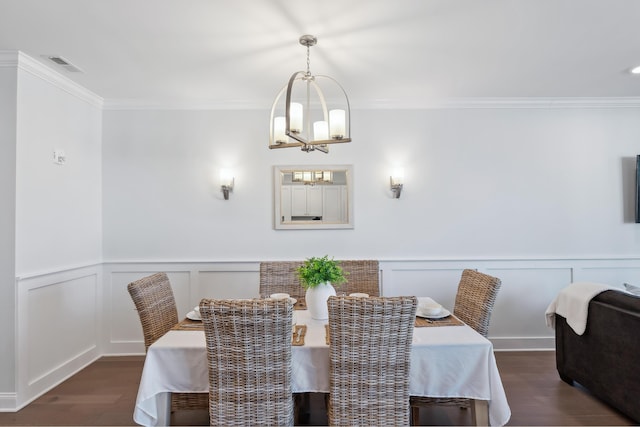 dining room featuring a chandelier, wood finished floors, visible vents, and crown molding