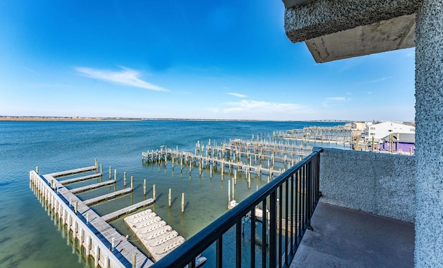 balcony with a water view and a boat dock