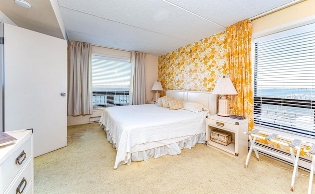 bedroom with a baseboard radiator, light colored carpet, baseboard heating, a textured ceiling, and wallpapered walls