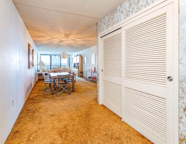 dining area featuring carpet floors, a notable chandelier, and a textured ceiling