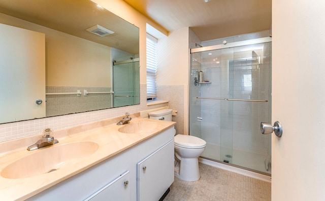 bathroom with toilet, a stall shower, visible vents, and a sink