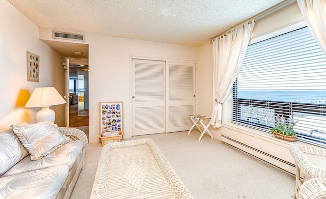 living room with a textured ceiling, a baseboard radiator, carpet flooring, and visible vents