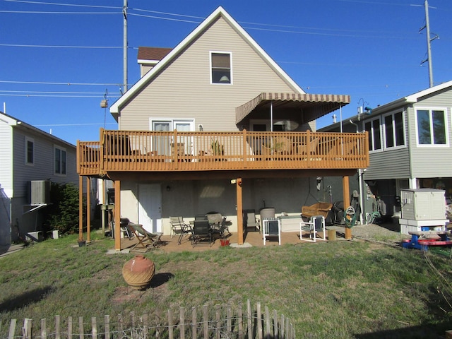 rear view of property with a lawn, a patio, and a deck