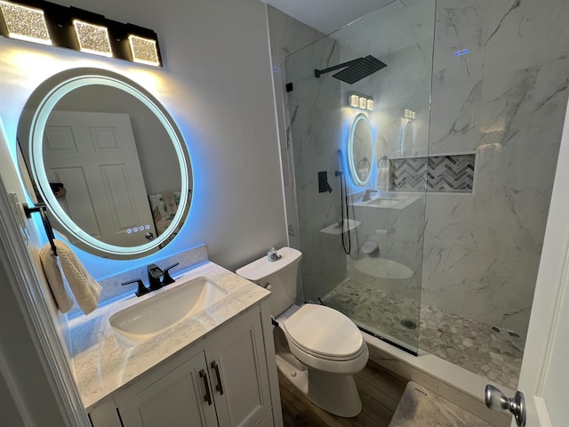 bathroom featuring tiled shower, vanity, and toilet